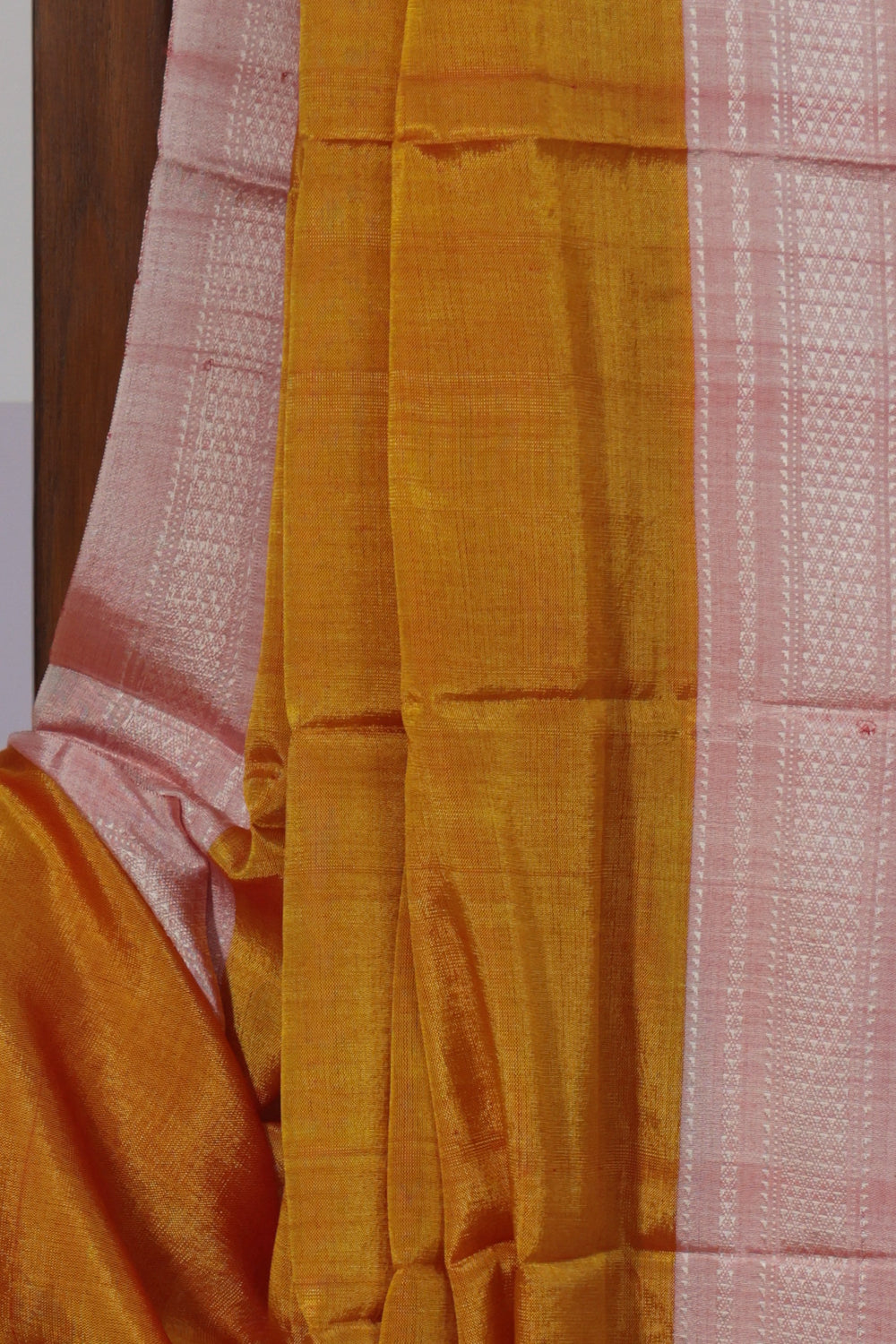 Close up of light pink Chikki Paras border on turmeric yellow Ilkal saree