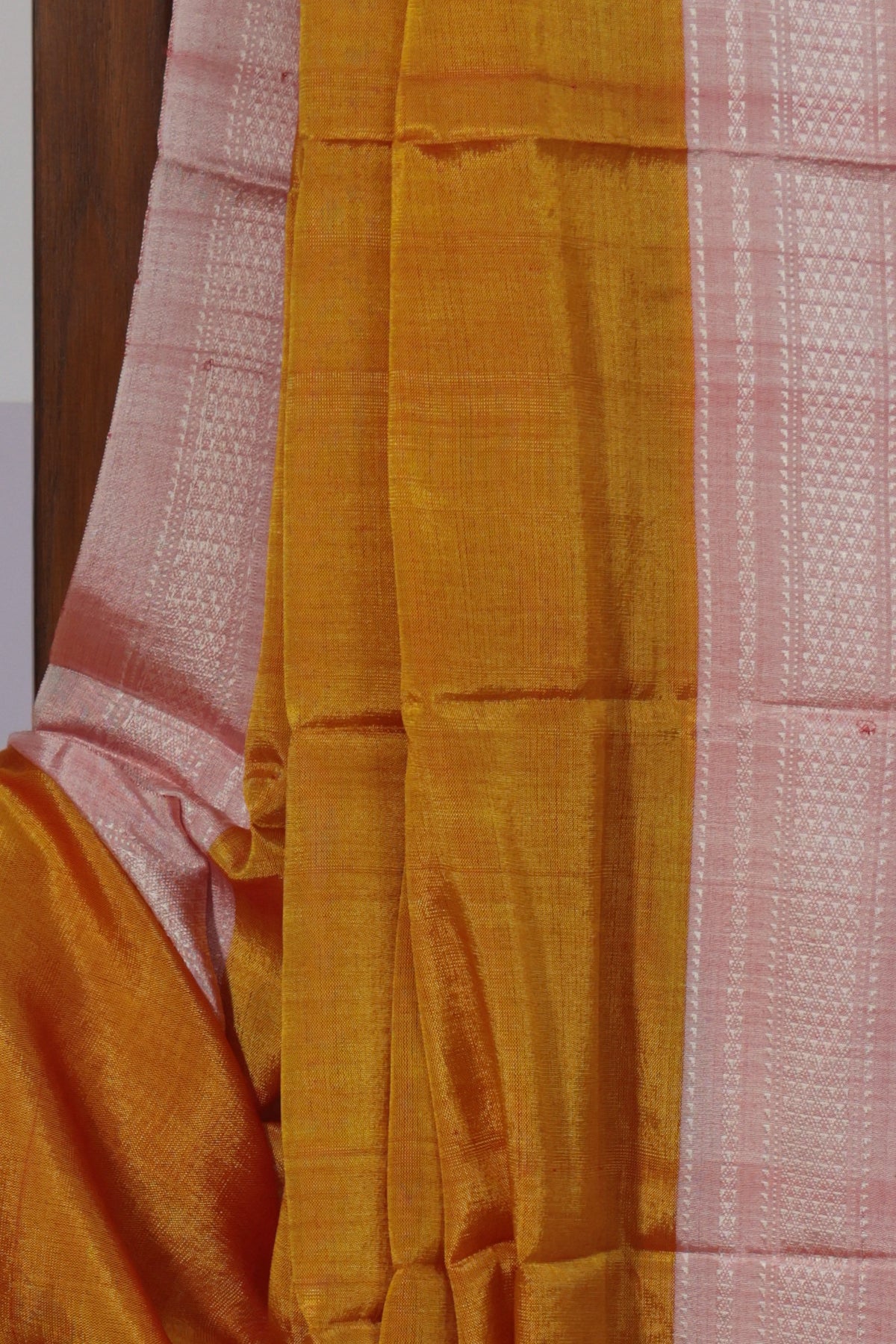 Close up of light pink Chikki Paras border on turmeric yellow Ilkal saree
