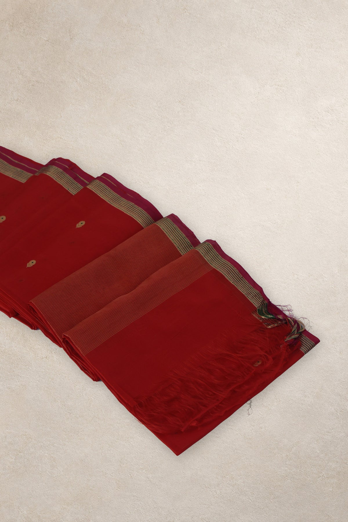Gold and green zari border with pink selvedge on red Chanderi saree