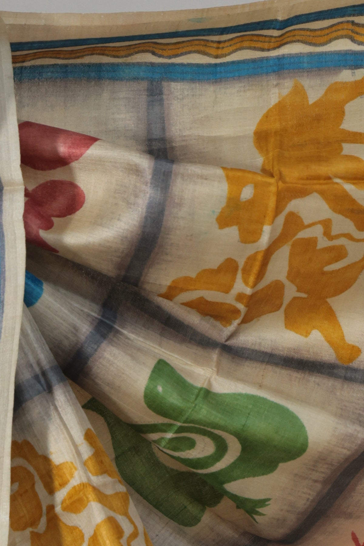 Hand painted yellow green and blue skirt border on Borno Batik Tussar saree
