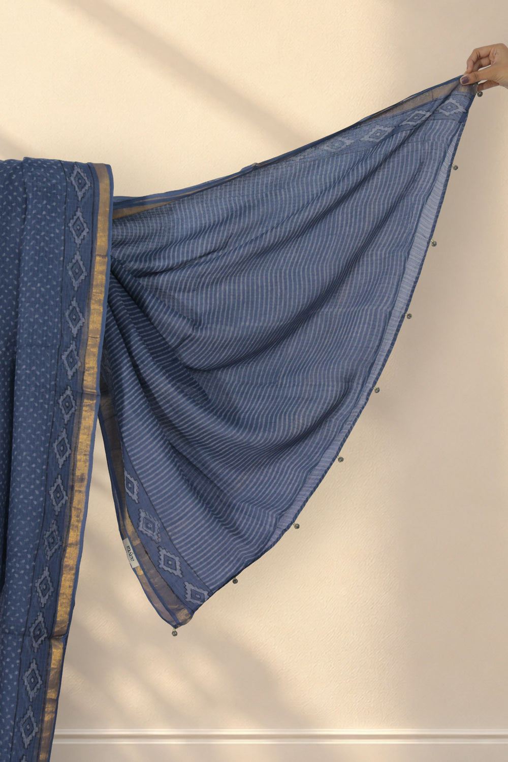 Golden zari border with large diamond motifs on Os Bindu grey Dabu saree