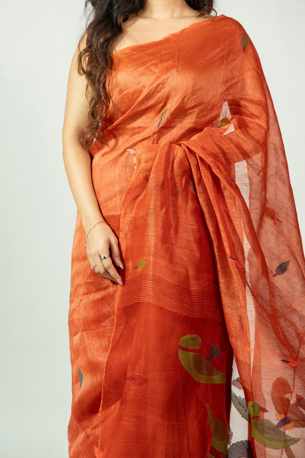 Rust orange silk linen saree with multicoloured woven leaf motifs